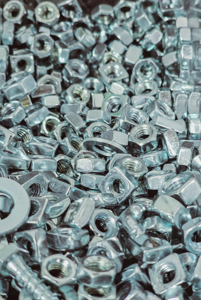 Home Close-up view of a pile of silver metal nuts and bolts with detailed textures.
