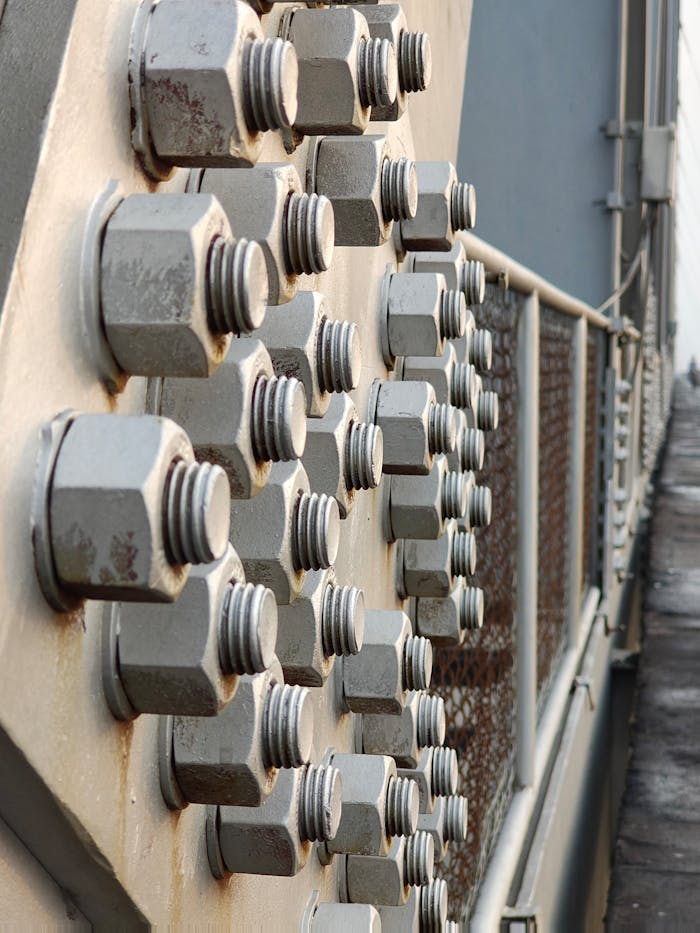 Detailed view of rusty metal bolts on an industrial structure, showcasing texture and decay.