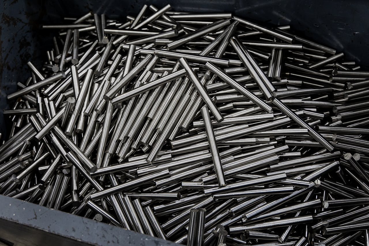 Close-up of numerous stainless steel rods in a container, showcasing industrial metal texture.